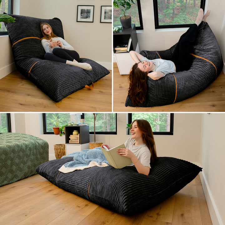 Three-panel collage showing a woman reclining on a large floor bean bag chair in a bright room with wood floors and windows. The bean bag is dark charcoal gray with subtle vertical texture and thin tan piping accents. 