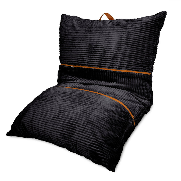 A black ribbed corduroy floor cushion with a matching back pillow, featuring a brown leather carry handle on top and contrasting brown piping details, shown on a plain white background. 