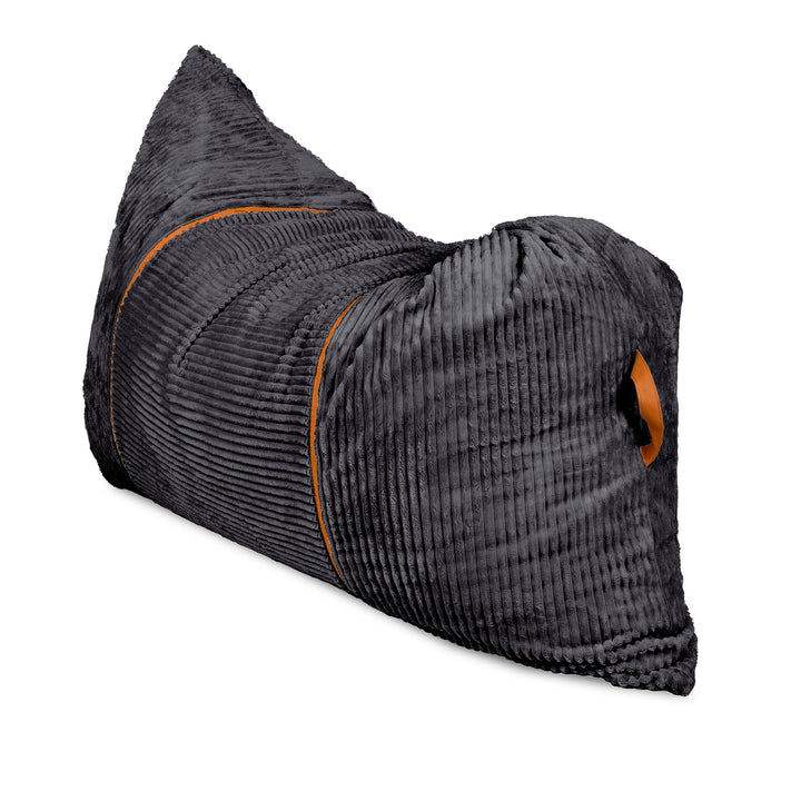 A dark gray ribbed corduroy travel pillow with orange contrast stitching and a small orange logo patch, shown on a plain white background. 