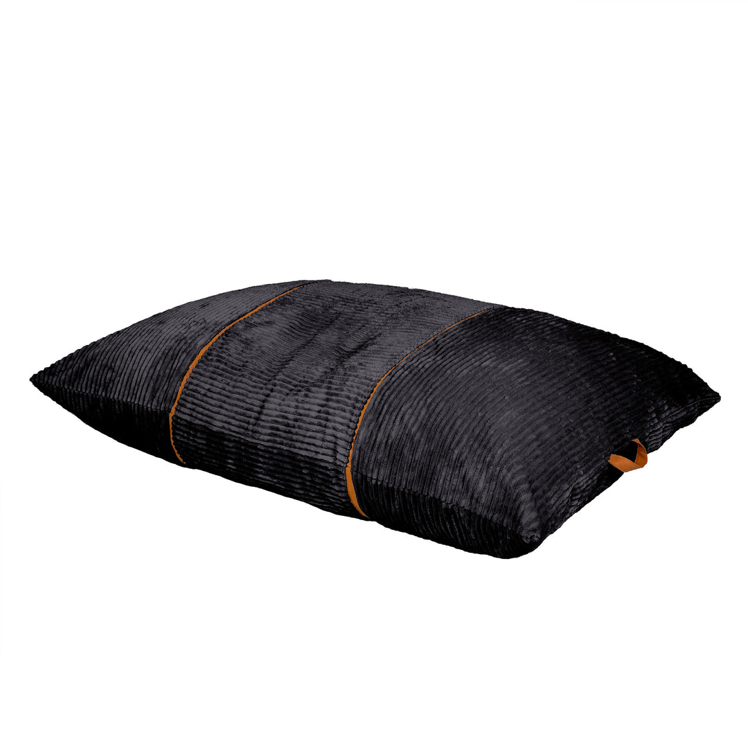 A rectangular black textured throw pillow with a ribbed corduroy-like fabric and thin orange-brown piping details, shown on a plain white background. 