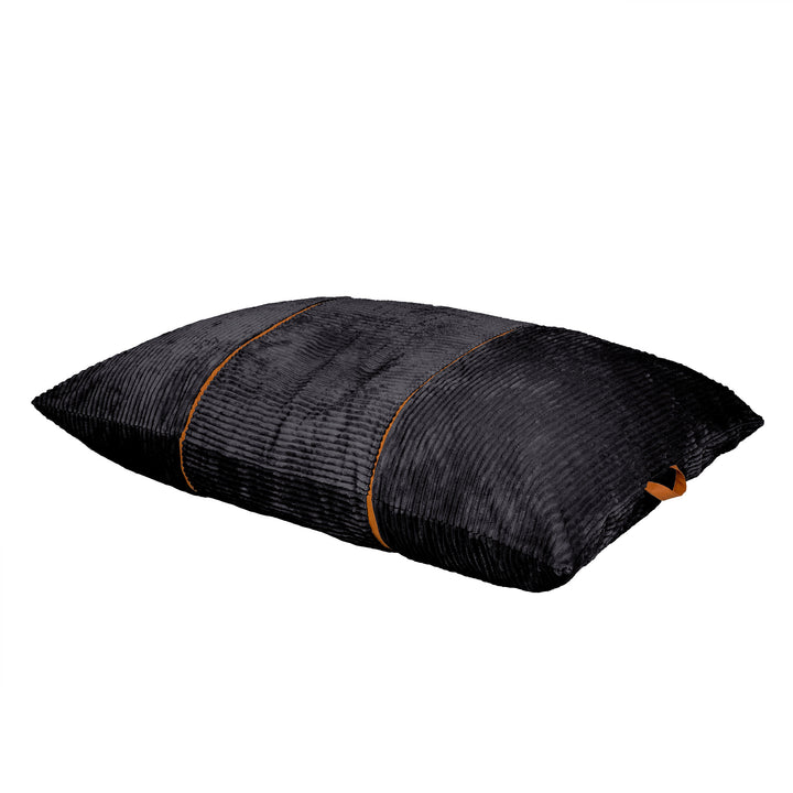 A rectangular black textured throw pillow with a ribbed corduroy-like fabric and thin orange-brown piping details, shown on a plain white background. 