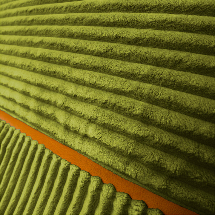Close-up of a ribbed, corduroy-like fabric in olive green with a bright orange accent stripe running diagonally across the lower left. 