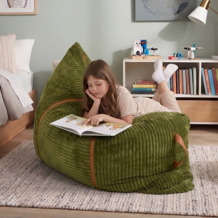 A young girl lies on a large olive green corduroy bean bag chair in a child&
