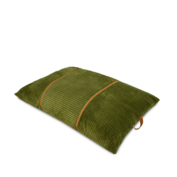 An olive green corduroy lumbar pillow with a thin tan leather strap and matching leather piping, shown on a plain white background. 