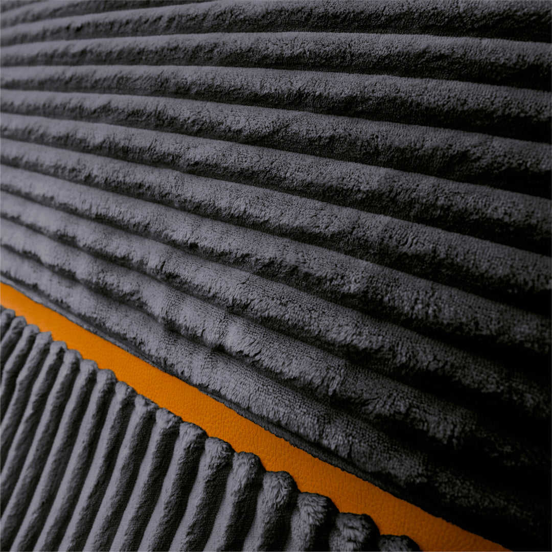 Close-up of a dark charcoal gray ribbed fabric surface with a diagonal orange accent stripe. 