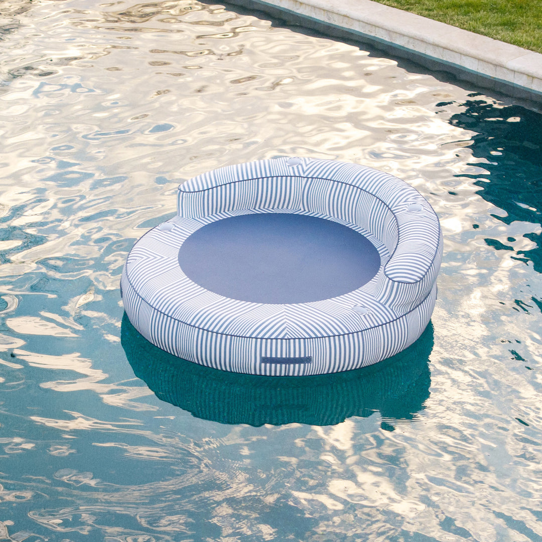 Inflatable pool float with striped pattern floating in a pool #color_weekend-navy-stripe-olefin