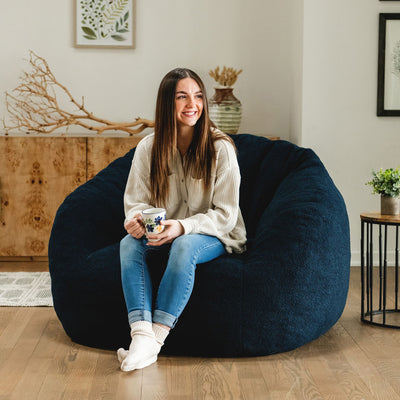 Woman sitting in a blue cloud-like chair in the living room 