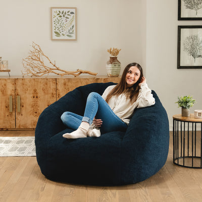 Woman relaxing in a blue cloud-like chair in the living room 