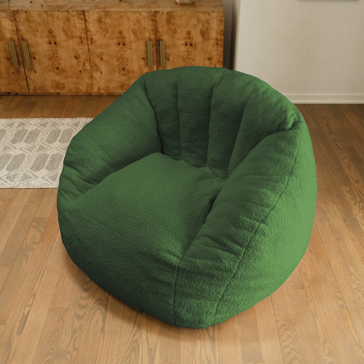 Green bean bag chair on a wooden floor with a wooden cabinet in the background. 