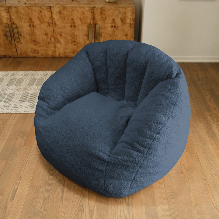 Blue bean bag chair on a wooden floor with a wooden cabinet in the background 