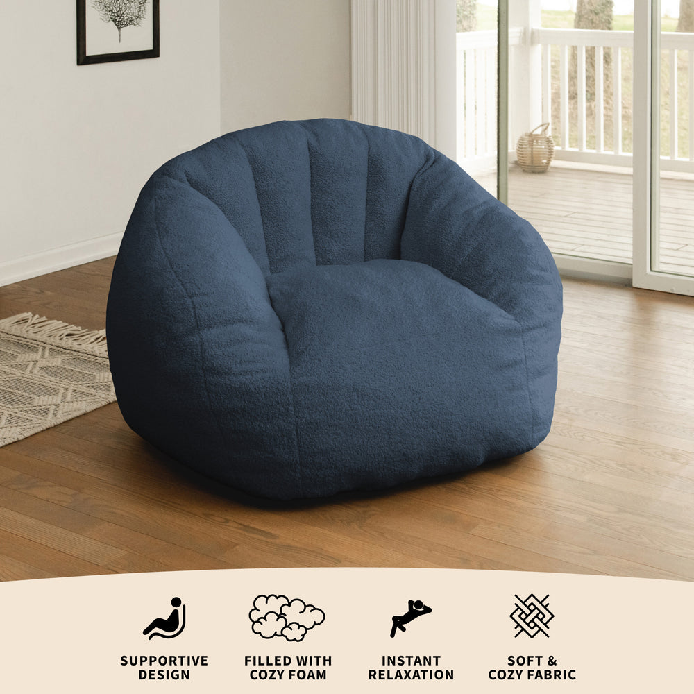 Blue bean bag chair in a room with wooden floor and large window #color_slate-blue-teddy-boucle