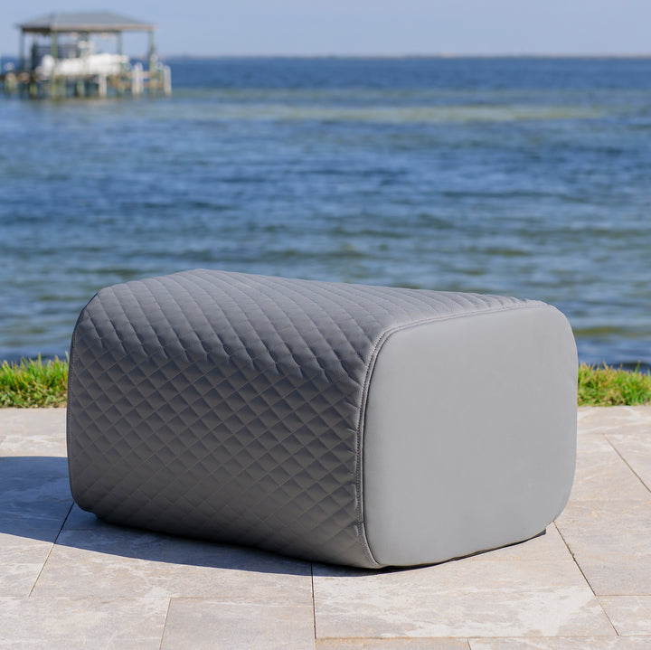 Gray quilted ottoman on a patio with ocean view #color_moonlit-gray-outdoor-vegan-leather