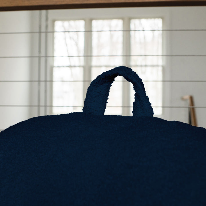 Navy blue bean bag chair handle with a blurred background #color_deep-blue-teddy-boucle