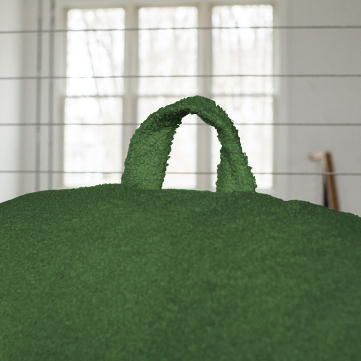 Green textured bag with handles against a neutral background 