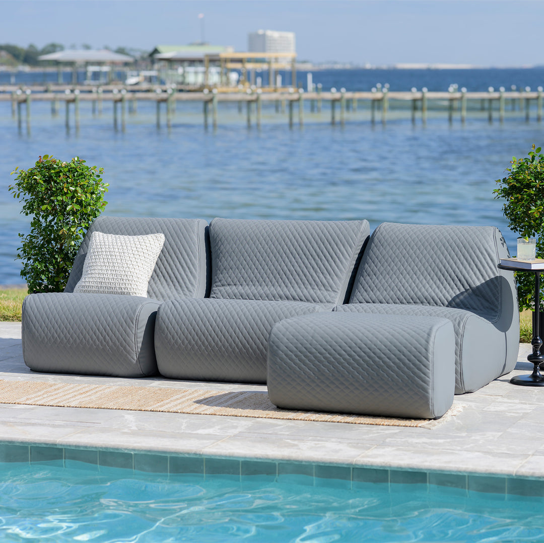Gray outdoor sofa with textured pattern by a pool and waterfront #color_moonlit-gray-outdoor-vegan-leather