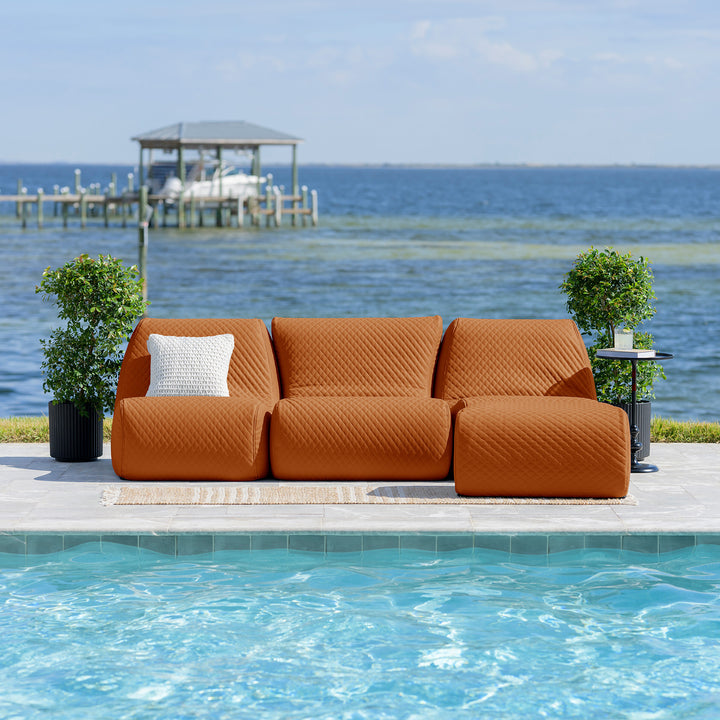 Orange outdoor sofa with a white pillow by a pool with a scenic  #color_honey-sand-outdoor-vegan-leatherbackground