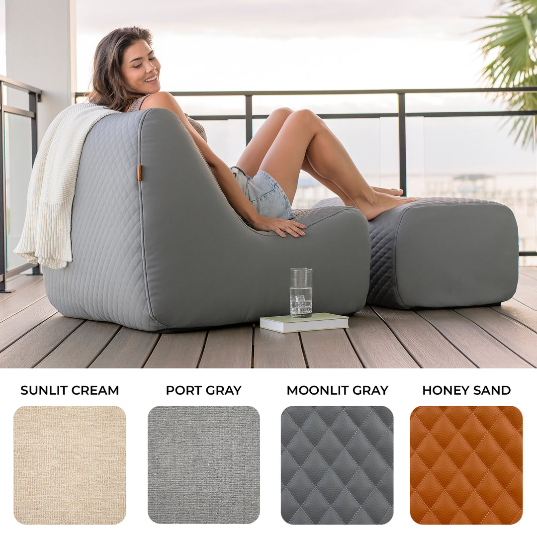 Woman sitting on a gray inflatable chair on a wooden deck with color swatches below. #color_moonlit-gray-outdoor-vegan-leather