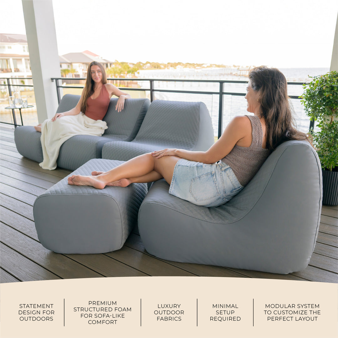 Two women sitting on a modern outdoor sofa set on a deck with scenic background #color_moonlit-gray-outdoor-vegan-leather