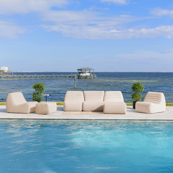 Beige outdoor sofa set by a pool with a scenic view of water and sky. #color_sunlit-cream-outdoor-performance-linen