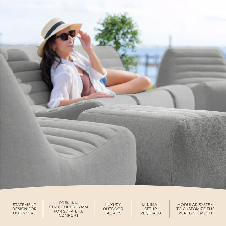 Woman relaxing on a gray inflatable outdoor sofa with text highlighting features. #color_port-gray-outdoor-performance-linen