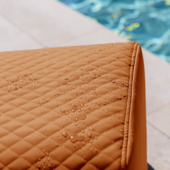Brown quilted fabric with water droplets near a pool #color_honey-sand-outdoor-vegan-leather