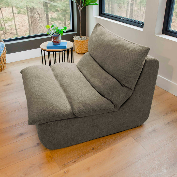 Gray sofa in a room with wooden flooring and windows. 