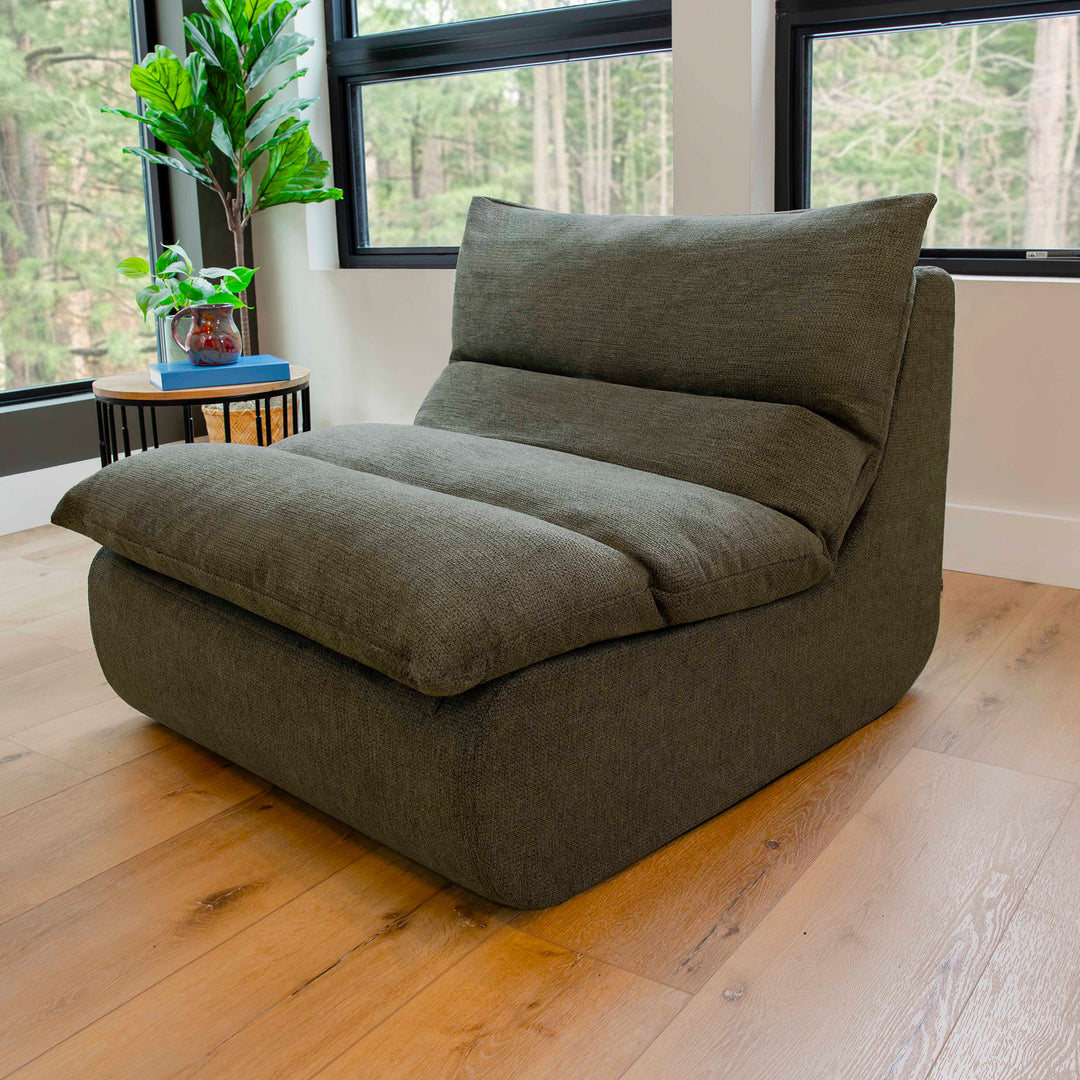Olive Green floor pillow on a wooden floor with a window view of trees. 