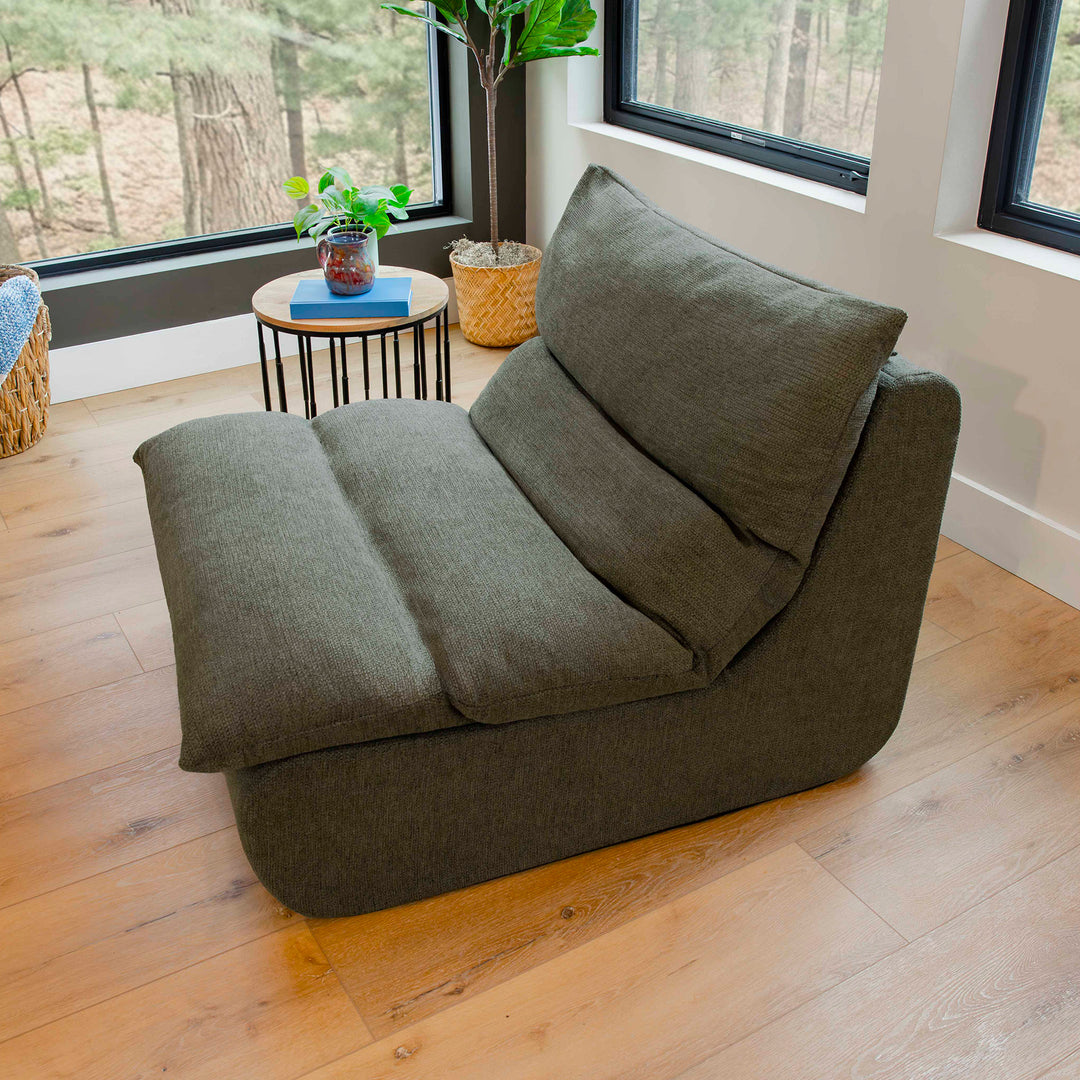 Gray bean bag chair in a room with large windows and wooden flooring. 