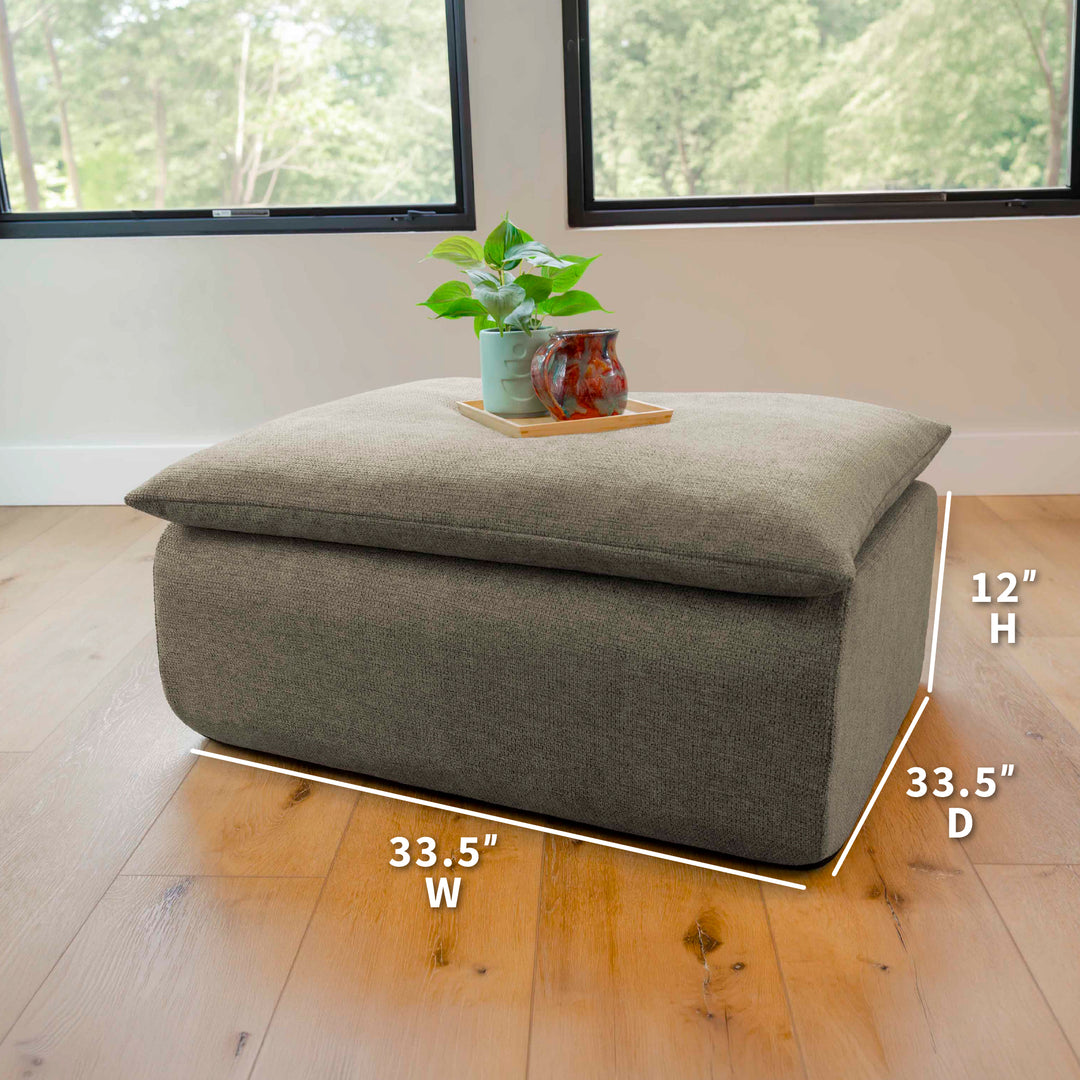 Gray ottoman with dimensions labeled on a wooden floor. 