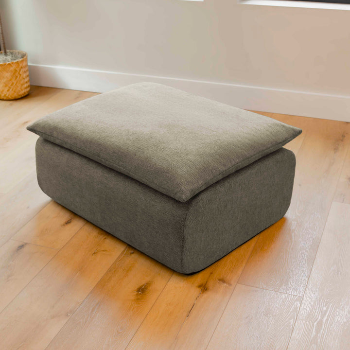 Gray ottoman on a wooden floor 