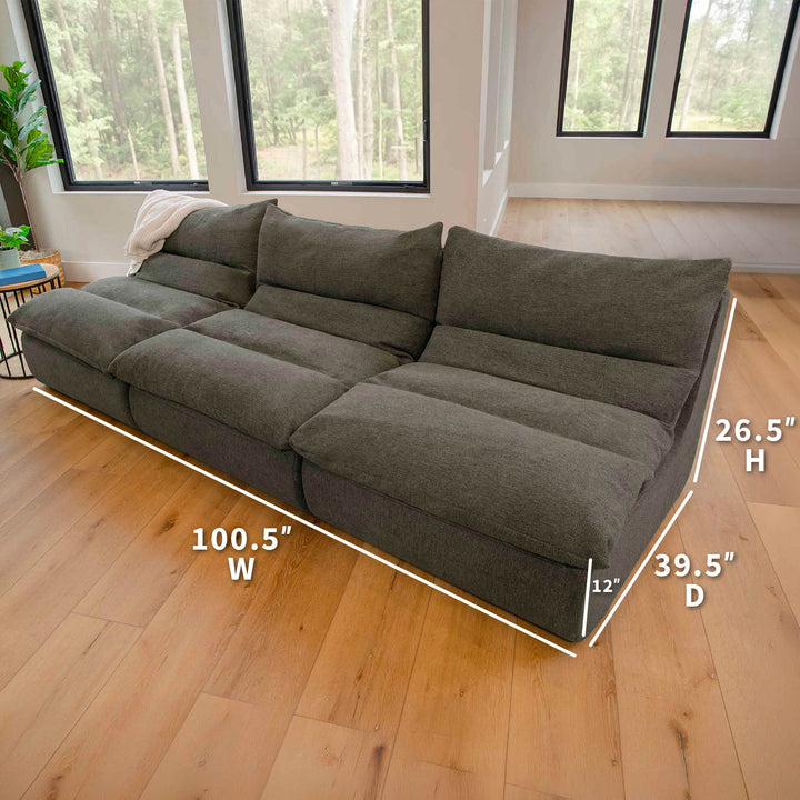 green sectional sofa with dimensions marked on a wooden floor. 