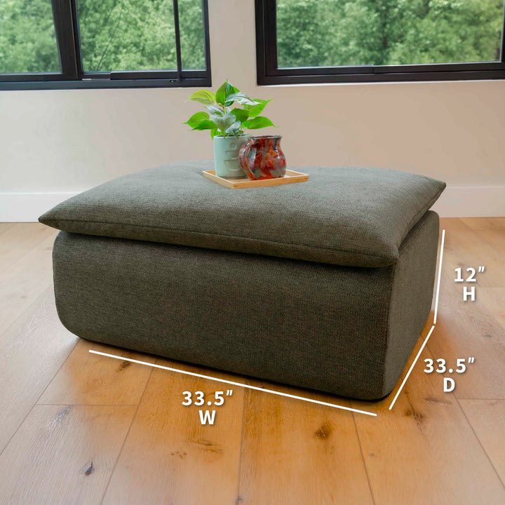 Green ottoman with dimensions labeled on a wooden floor. 