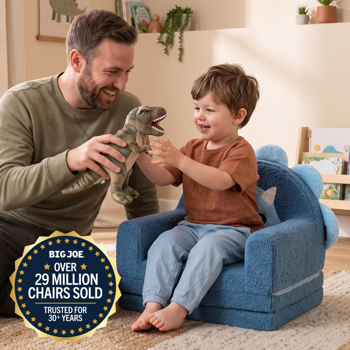 A man and a young boy smile and play together in a child-sized blue plush chair. The boy holds a green dinosaur toy, and a large gold and blue badge in the lower left reads &