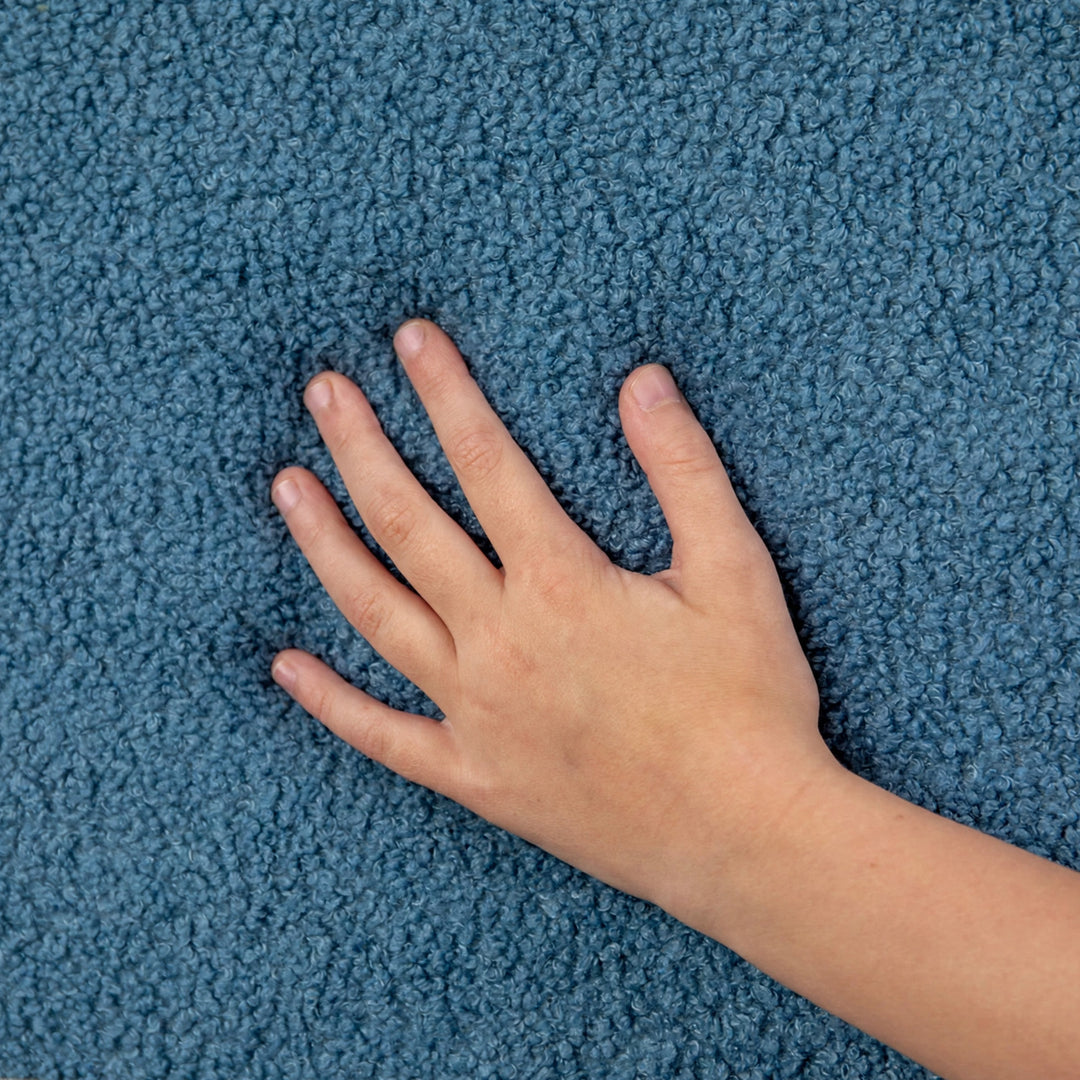 A close-up of a textured blue carpet with a child&