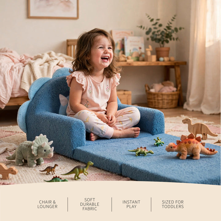 A young child sits happily in a blue plush toddler chair lounger on a carpeted floor, surrounded by dinosaur toys in a softly lit nursery. Text at the bottom highlights the chair&