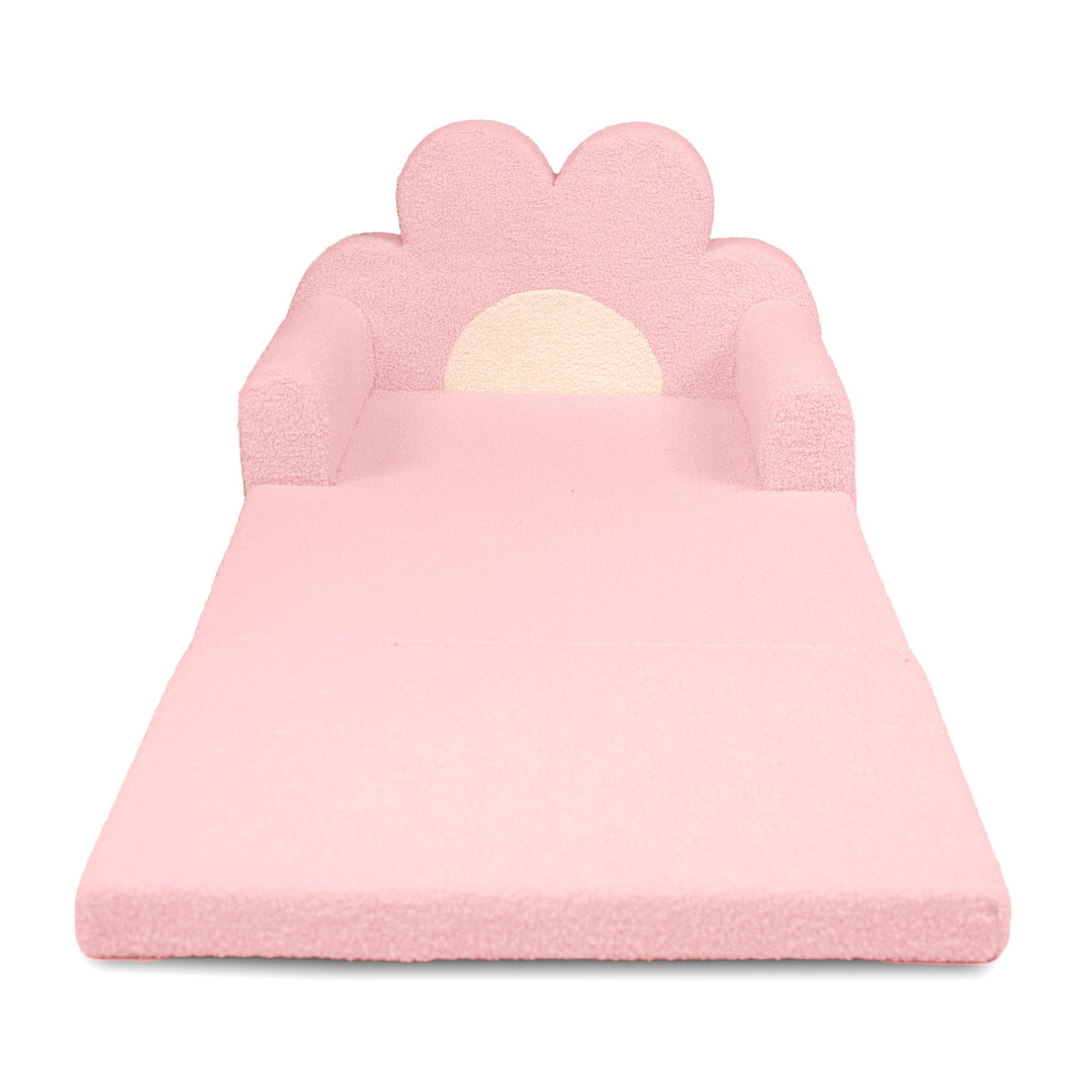 A pink foam play mat shaped like a flower bed, featuring a flower-shaped backrest with armrests and a cream-colored sun design in the center, shown on a plain white background. 