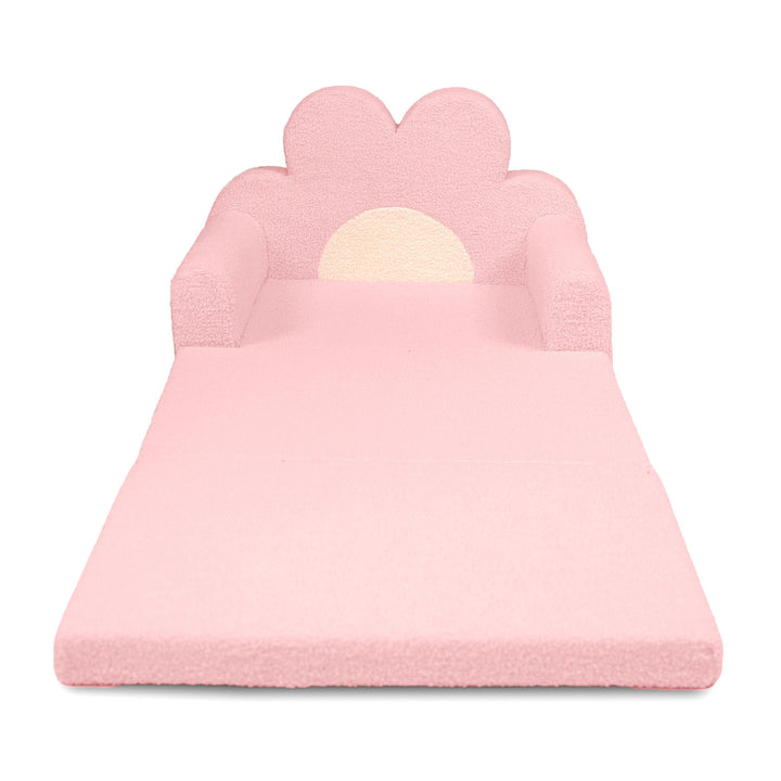 A pink foam play mat shaped like a flower bed, featuring a flower-shaped backrest with armrests and a cream-colored sun design in the center, shown on a plain white background. 