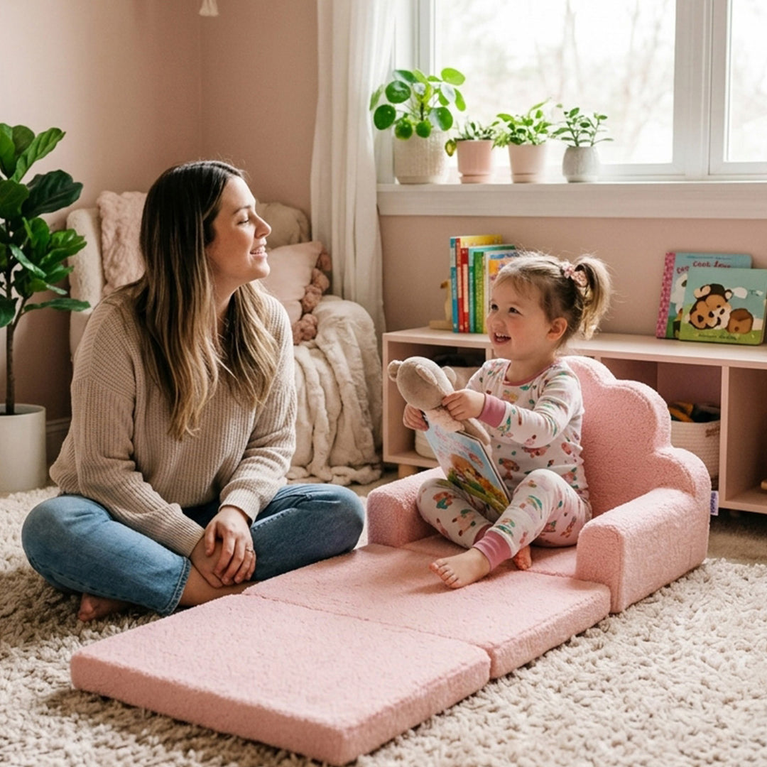 A woman and a young child play together on a pink foldable foam play mat in a cozy, warm-toned children&