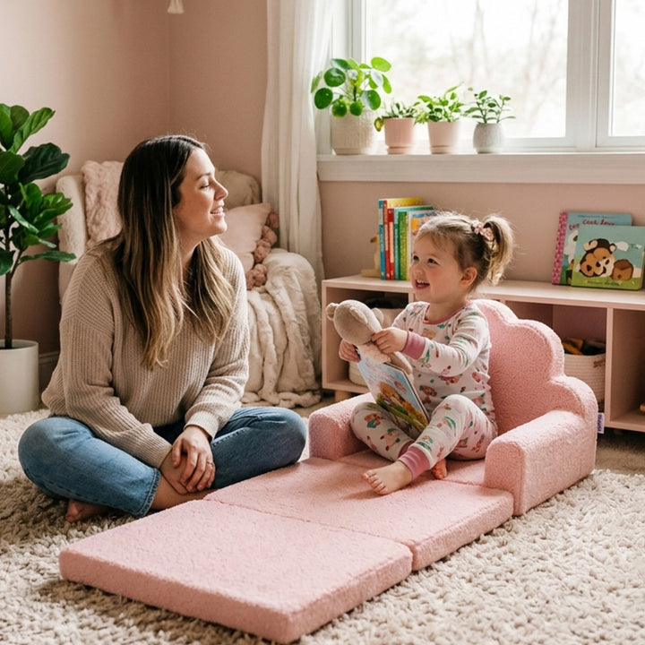 A woman and a young child play together on a pink foldable foam play mat in a cozy, warm-toned children&