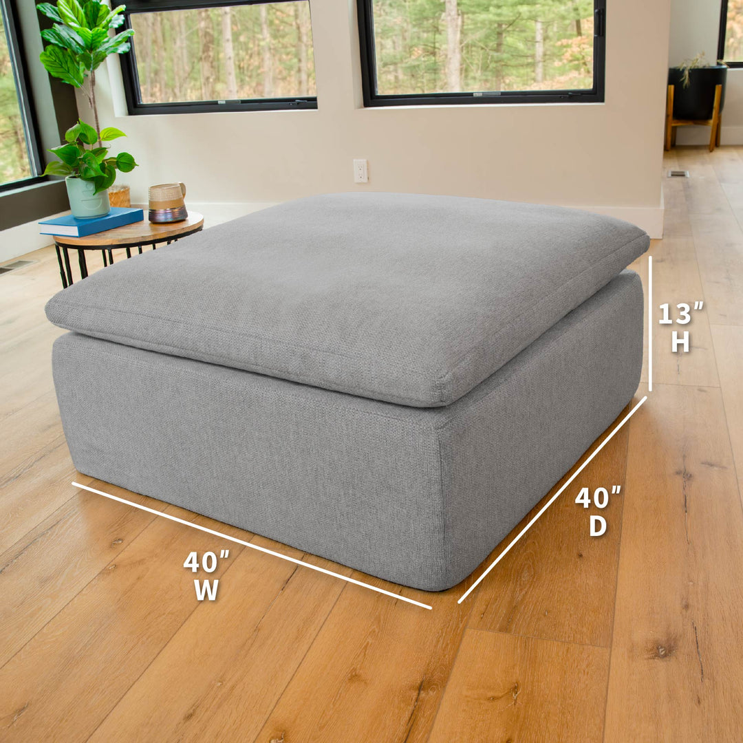 Gray ottoman with dimensions labeled on a wooden floor. 