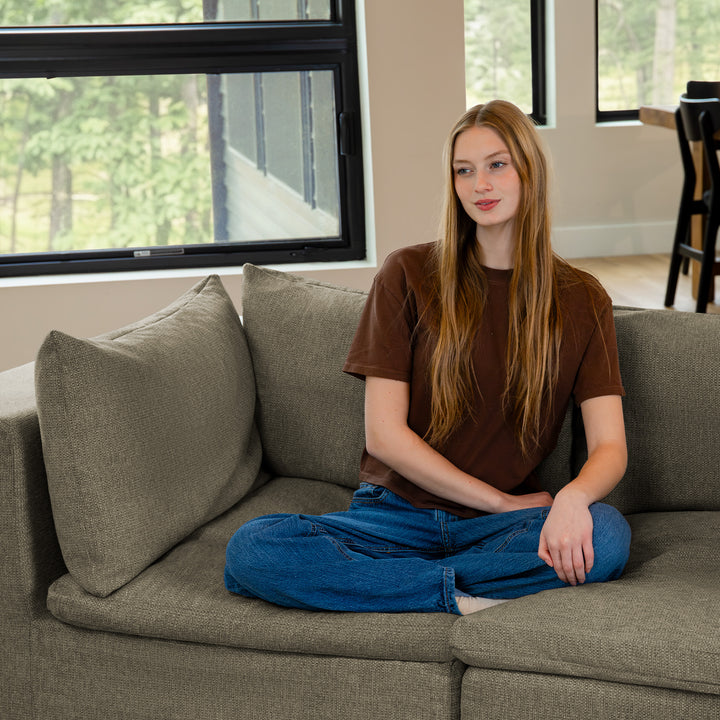 Woman sitting on a loveseat sofa 
