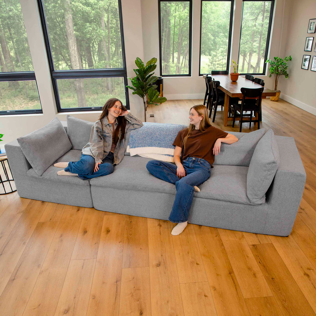Two women relaxing on a pillow-top couch 