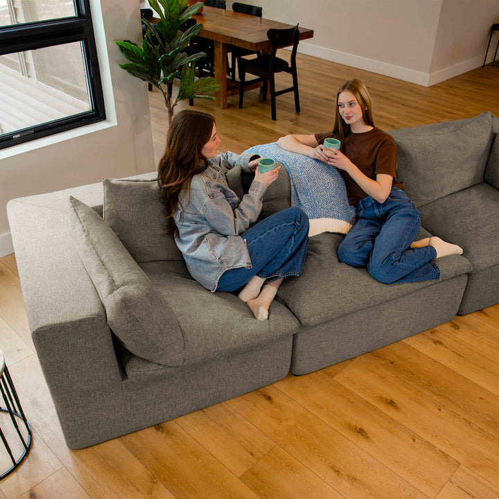 Two women drinking coffee on a sofa 