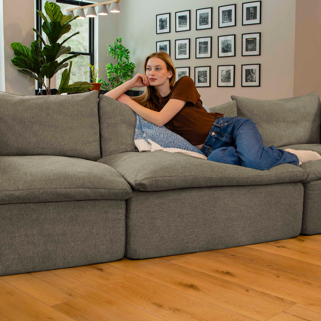 Woman relaxing on a sectional pillow-top sofa 