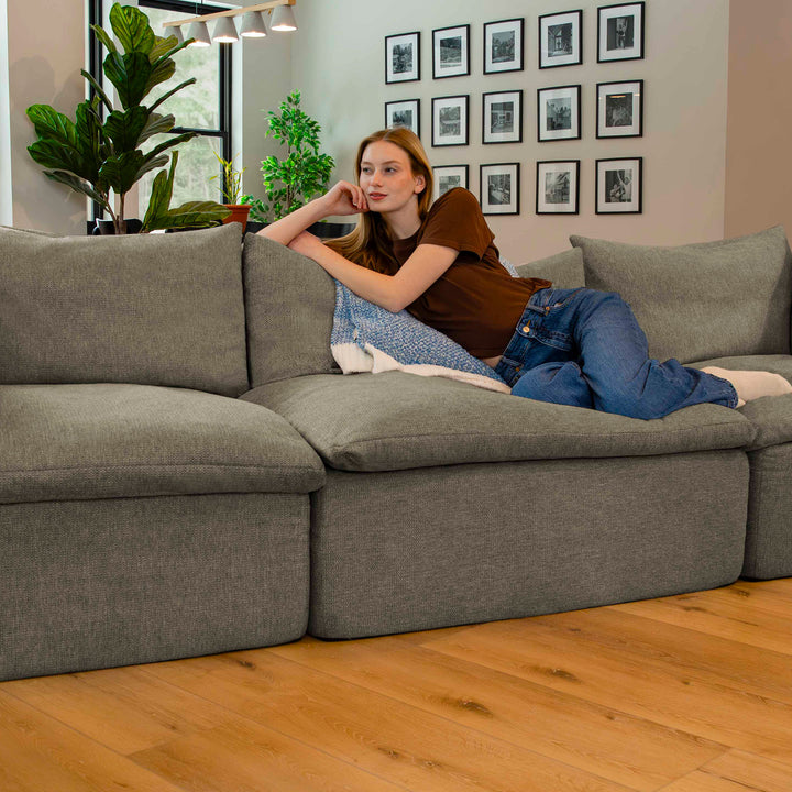 Woman relaxing on a sectional pillow-top sofa 