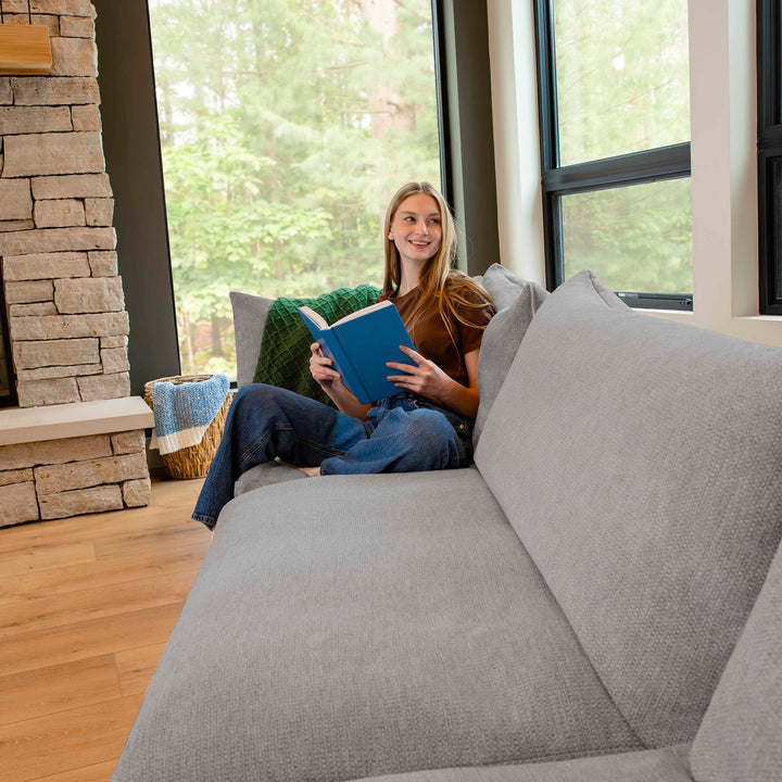 Woman reading on a sectional couch 