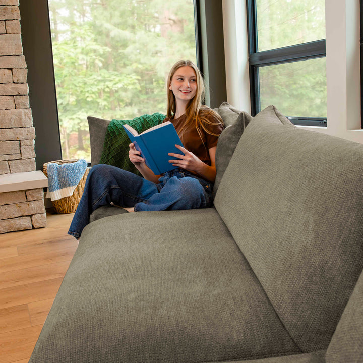 Woman reading a book on a sofa 