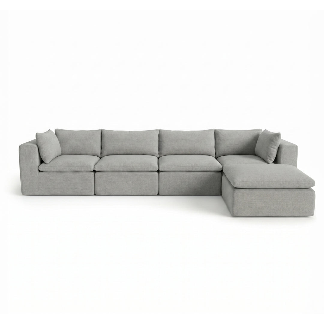 A light gray modular sectional sofa with a right-facing chaise lounge and matching throw pillows, shown against a plain white background. 