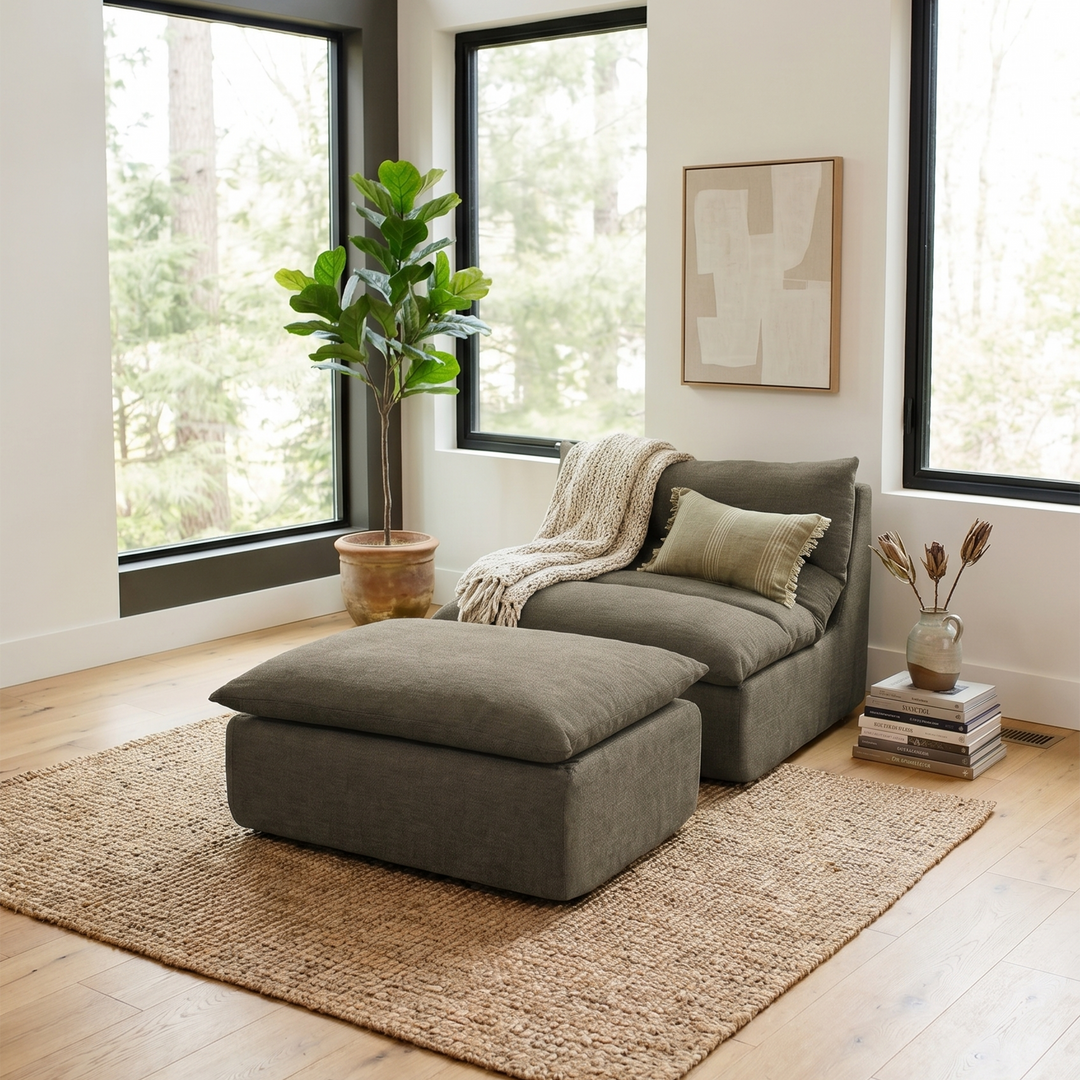 Gray sectional sofa with ottoman in a room with large windows and a plant. #color_misty-gray-terra-knit
