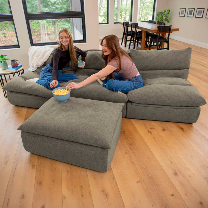 Two women eating popcorn on a 4pc driftscape sectional couch set 